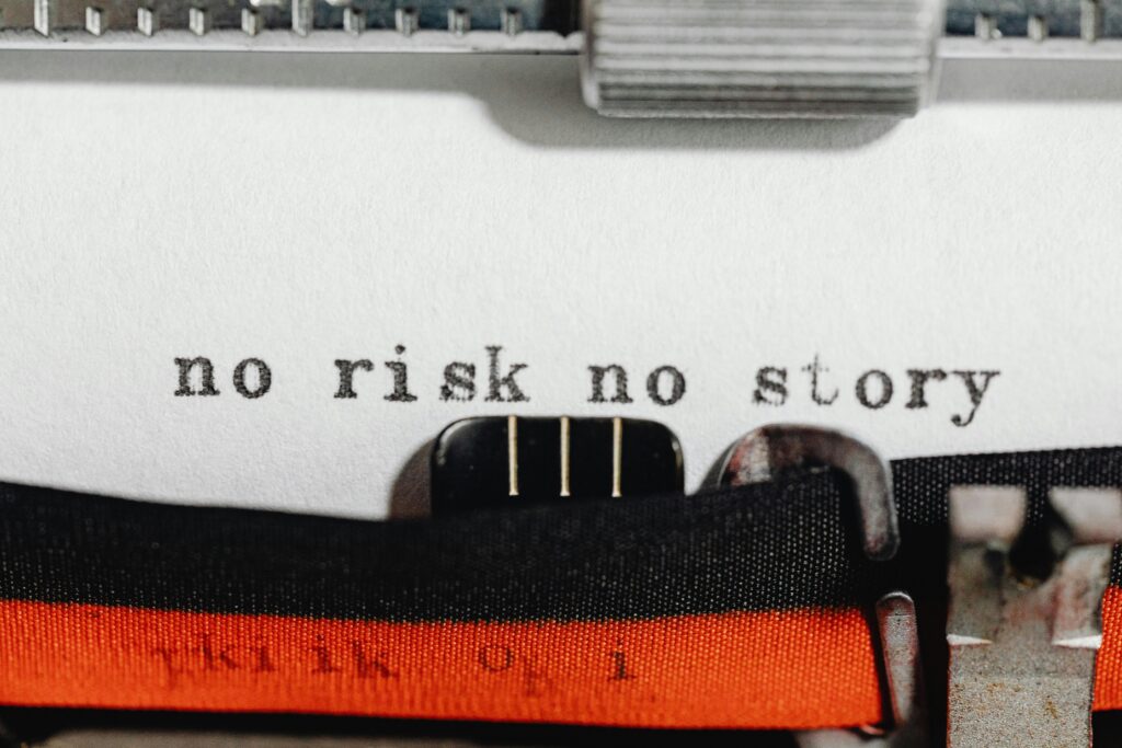 Close-up of a vintage typewriter typing 'no risk no story' on paper.