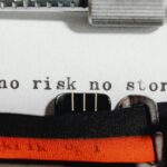 Close-up of a vintage typewriter typing 'no risk no story' on paper.