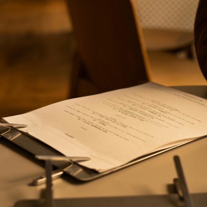 Detailed view of a clipboard with documents in a cozy café environment, offering a warm and inviting atmosphere.